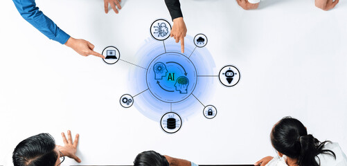 Diverse professionals collaborate over a table, pointing at a digital representation of artificial...