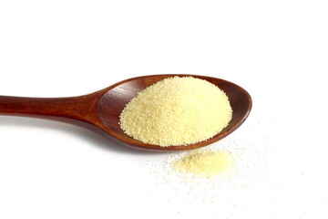 There is a wooden spoon with semolina on a white background.