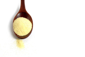 There is a wooden spoon with semolina on a white background.	