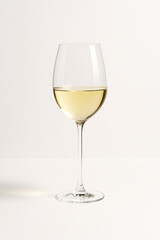 ワイングラスに入った白ワイン　白背景　縦長