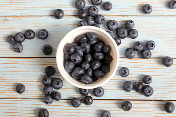 There is a bowl of ripe blueberries on the table.