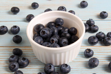 There is a bowl of ripe blueberries on the table.	