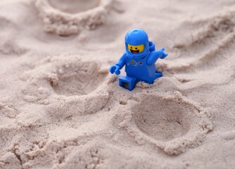 Naklejka premium Tambov, Russian Federation - July 28, 2024 Lego Benny astronaut minifigure walking on sand on a planet