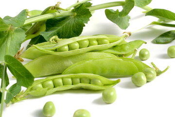 Green pea pods with leaves lie on a white background.	