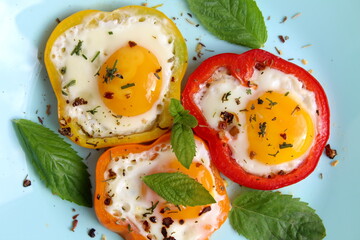 On the plate there is a fried egg inside a sliced ​​pepper.	
