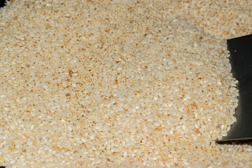 closeup of roasted white til or sesame seeds in a kadhai after roasting it at home.