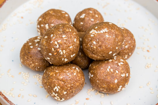 Makar Sankranti special til gud laddu in a white plate. highlights homemade traditional food.