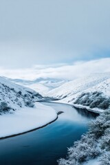 Fototapeta premium Serene winter landscape with snowy mountains and calm river