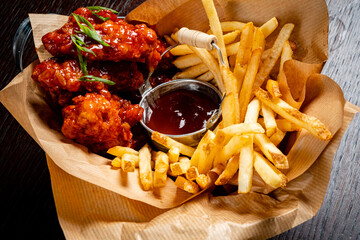 Juicy chicken wings glazed in a spicy sauce accompany perfectly fried golden fries