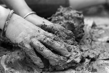 Young woman sculpting clay idol by hand during traditional craft process