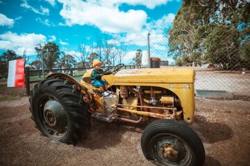 A rustic yellow tractor is parked in the midst of a beautiful, serene landscape