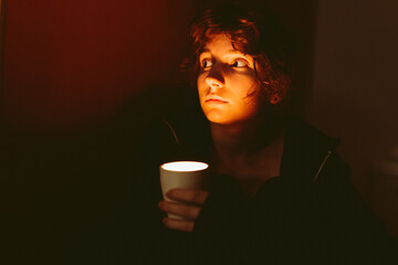 young woman with a candle in a dark room