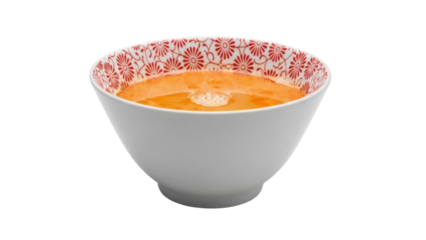 Orange soup in a white bowl with red floral pattern isolated PNG, healthy homemade meal on transparent background