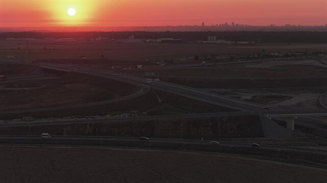Bucharest A0 highway 4k video. Aerial view of a curved section of the A0 highway near Bucharest during the warm light of sunrise, highlighting the road lines and safety barriers. Roads of Romania.