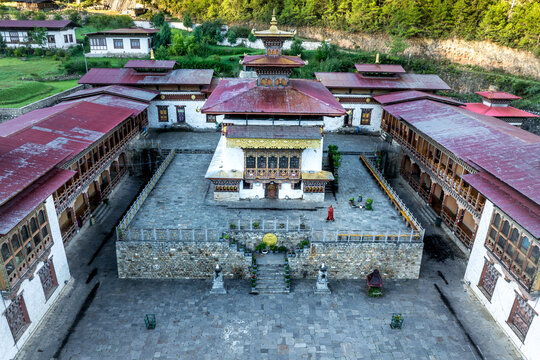 Aerial view of the Karpo Lhakhang's striking white walls and red roofs contrast with the surrounding lush greenery, a serene fusion of architecture and nature, Karpo Lhakhang, Haa, Bhutan.