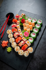 Colorful sushi selection showcases a variety of rolls, garnished with vibrant herbs and sauces