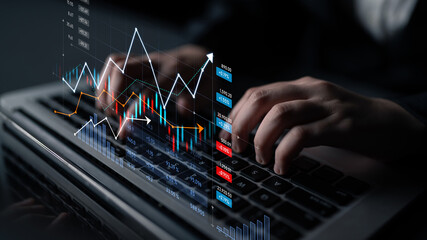 A focused business professional types on a laptop, analyzing digital financial data with vibrant...