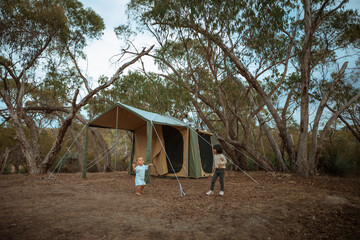 A joyful family is creating lasting memories while enjoying a delightful camping experience in a serene forest setting