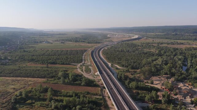 A1 highway from Bucharest to Pitesit Curtea de Arges and Sibiu 4K video. Newly built A1 Highway in Romania, cutting through rural fields and valleys, with mountains visible in the distance.
