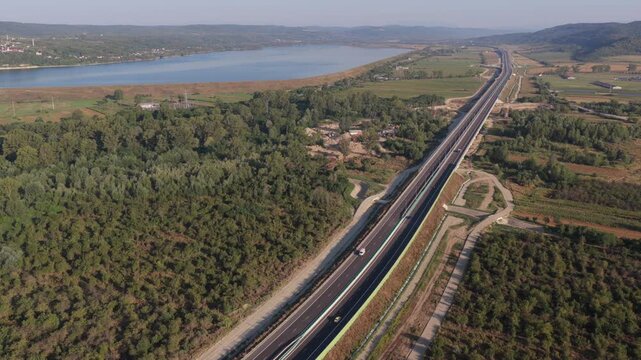 A1 highway from Bucharest to Pitesit Curtea de Arges and Sibiu 4K video. Newly built A1 Highway in Romania, cutting through rural fields and valleys, with mountains visible in the distance.