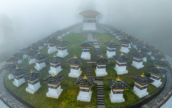 Aerial view of a mesmerizing assembly of chortens shrouded in ethereal mist, Dochula Chorten, Thimphu, Bhutan.