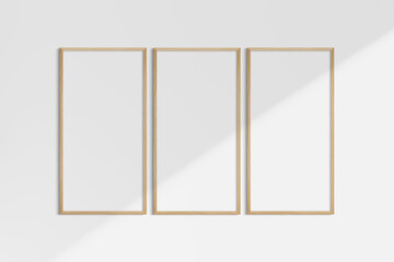 Frame mockup 1:2. Set of three thin cherry wood frames. Gallery wall mockup, set of 3 frames. Clean, modern, minimalist, bright. Portrait. Vertical. Shadow overlay.