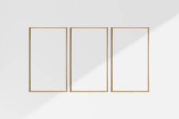 Frame mockup 9:16. Set of three thin cherry wood frames. Gallery wall mockup, set of 3 frames. Clean, modern, minimalist, bright. Portrait. Vertical. Shadow overlay.