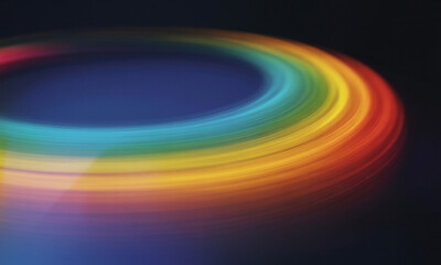Swirling Rainbow Light Streaks Forming a Circular Motion on a Dark Blue Background abstract colors