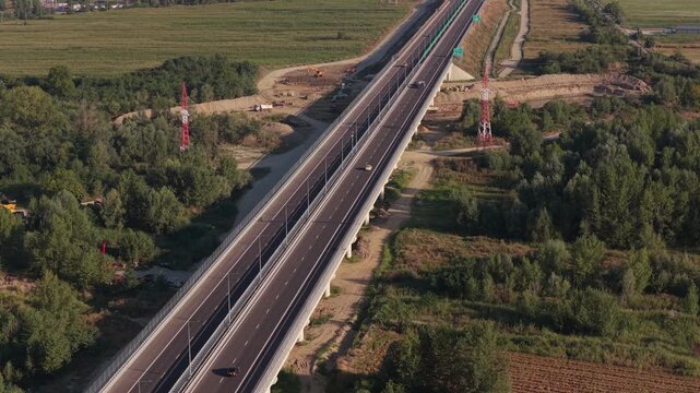 A1 highway from Bucharest to Pitesit Curtea de Arges and Sibiu 4K video. Newly built A1 Highway in Romania, cutting through rural fields and valleys, with mountains visible in the distance.