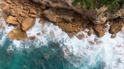 Rocks and waves meet at the shore during bright daylight in a coastal area