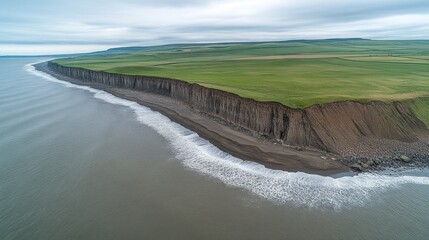 Coastal cliffs meet a dark beach