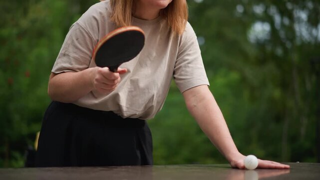 Woman Thoughtfully Positions Ball Before Game, Female Athlete Attentively Sets Up For Serve In Match, Female Sports Participant Meticulously Arranges Ball On Table Prior To Beginning Her Play