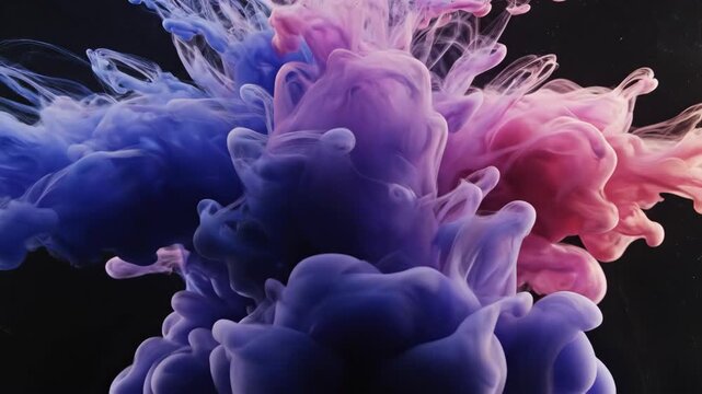 Plumes of blue and pink color dissolve in water, against a black backdrop