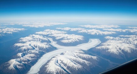 Aerial shot of snow-capped mountains and a winding glacier