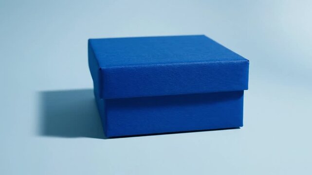 Vibrant blue gift box on light blue background with shadow