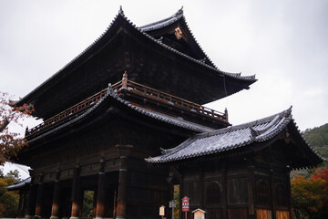 Fototapeta premium Traditional Japanese Pagoda Temple With Curved Roofs and Ornate Wooden Detailing in Dark Architecture