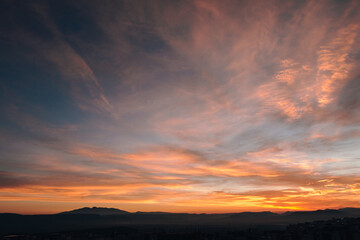Obraz premium Dramatic blue hour sky with cloud layers over hill silhouettes