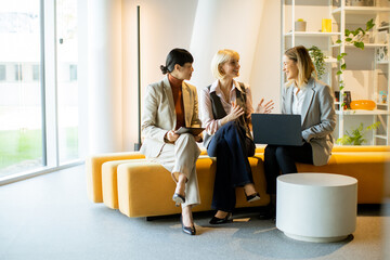 Business meeting and discussion among three women in a modern office setting