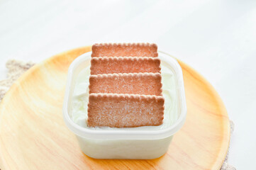 容器入ったヨーグルトにサブレを刺す