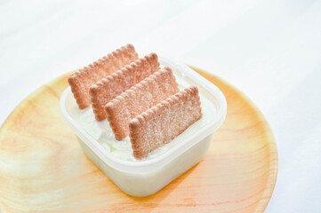 容器入ったヨーグルトにサブレを刺す