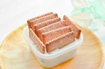 容器入ったヨーグルトにサブレを刺す