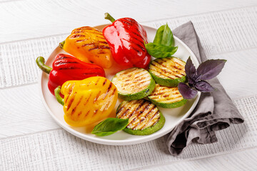 Assorted grilled vegetables including bell peppers, zucchini, eggplant, and fresh herbs