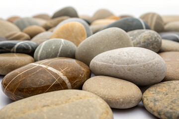 Geological display of various smooth, rounded stones creating a serpentine trail in a high-key studio shot