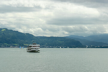Passenger Ferry on Mountain Lake Under Cloudy Sky