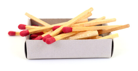 Open matchbox filled with wooden matches isolated on white