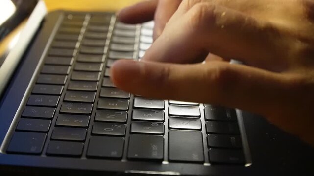 Close up of a person's hands opening a laptop lid and starting to type on the keyboard on a wooden desk in a home office, symbolizing remote work, digital communication, and productivity