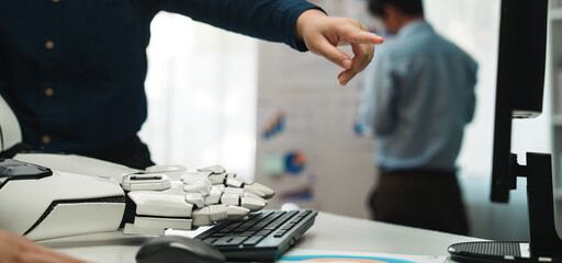 A focused interaction between a human and a robot in a modern office setting, highlighting collaboration and the use of technology for data analysis and productivity.Noogenesis
