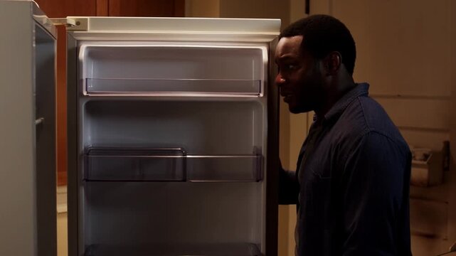 A man opening an empty fridge in the kitchen Stock Video