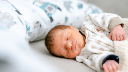 Sleeping newborn baby at home with cozy bedding