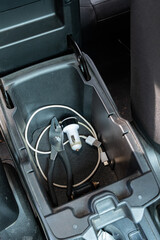 Car center console with pliers, USB cable, and charger adapters